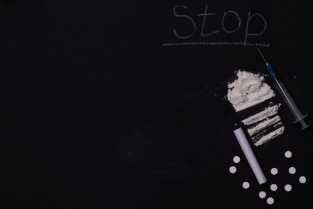 International Day against Drug Abuse and Illicit Trafficking. The photo shows a syringe and drugs on a black background.の写真素材