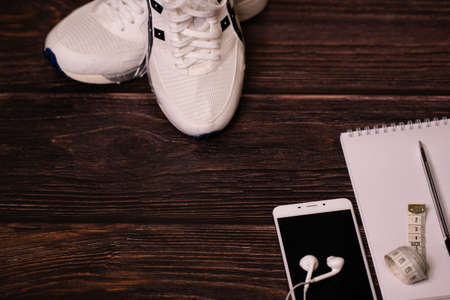Preparation and preparation of a training plan, yoga. Sneakers, a notebook with a pen, a phone and headphones. Stort. Top view, flat lay.の写真素材