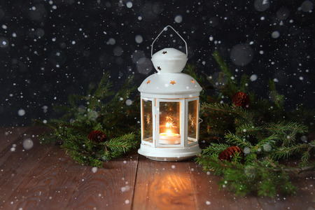 White Christmas lamp and fir-tree branches on a wooden surfaceの写真素材