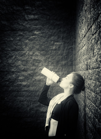 young woman drinks water after training -- tonedの写真素材