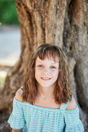 One cute little girl in the park on a summer evening