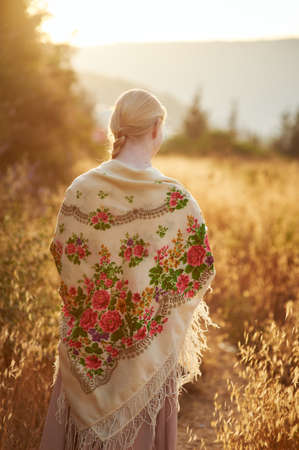 girl on the field in the evening. girl of slavic appearance in a beautiful placeの写真素材