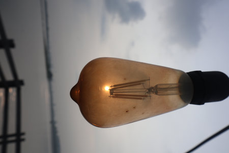 closeup shot of a light bulb against the cloudy skyの写真素材