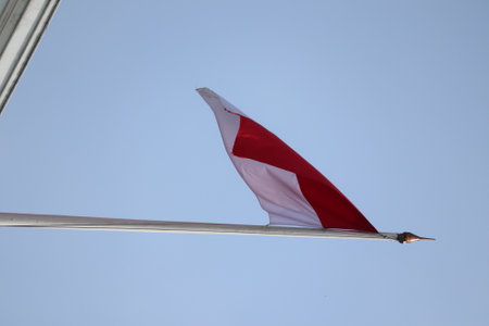 Indonesian flag waving in the wind against a blue sky.の写真素材
