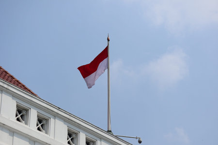 Indonesia flag on the roof of building with blue sky backgroundの写真素材