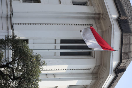 Indonesian flag waving in the wind on a building in Jakarta, Indonesiaの写真素材
