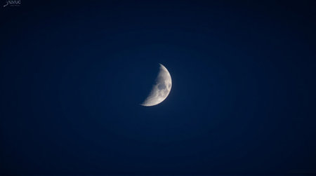 Capture the ethereal beauty of the crescent moon against a deep blue night sky for creative projectsの素材