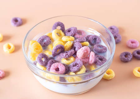 multi-colored multi-slag breakfast rings with milk in a glass bowl. Fruit-flavored breakfast cerealsの写真素材