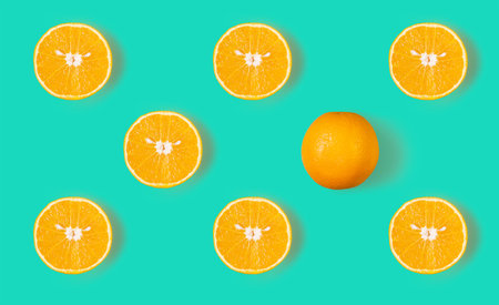 Fruit pattern of fresh orange slices and a whole orange on a blue background. Top view, copy space....