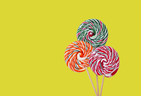 Colorful lollipops on yellow background. Copy space.の写真素材