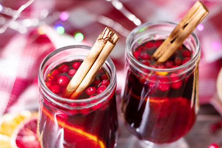 two glasses of mulled wine. Grog with cinnamon, orange and berries