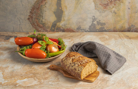 Traditional wooden plate with fresh seasonal vegetables: green pepper, tomato, onion, carrot, cucumber, basil, dill; bread, textile on brown vintage background, top viewの写真素材