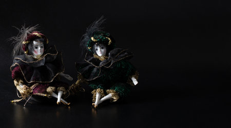 Porcelain dolls, realistic vintage toys with grey eyes. The dolls are dressed in a carnival outfit, decorated with gold. Harlequinの写真素材