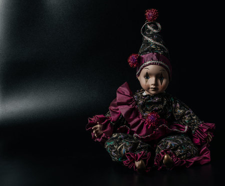 Amazing realistic porcelain doll, toy, harlequin, selective focus, vintage concept, space for textの写真素材
