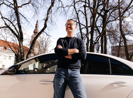 Business man standing next to a new white premium car, the concept of success