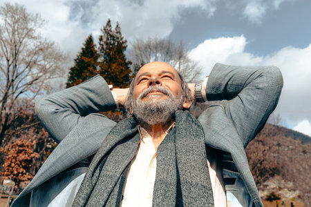 Portrait of a confident, handsome, mature man, pensioner, grandfather in the small townの写真素材