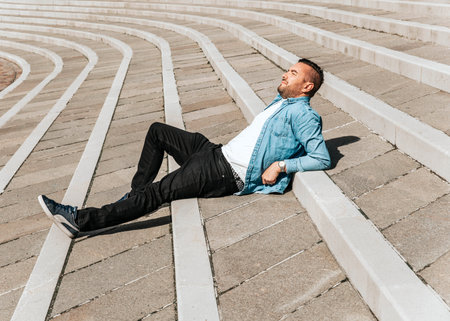 Portrait of a handsome hipster man in a jean jacket. A man in a big city on the street, a life style conceptの写真素材