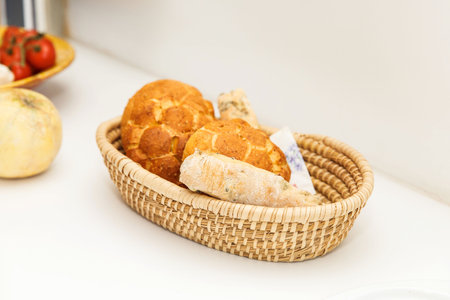 Basket containing fresh bakery bread, crispy loaves, and baguette on a white surface, homemade...