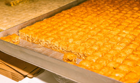 Baklava freshly baked, cut into small pieces, laid out on a baking tray, traditional dessert concept