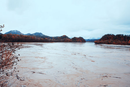 River majestically flowing through a mountain landscape, autumn foliage, water tranquility conceptの写真素材