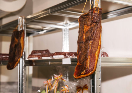 Smokehouse, metal rack in kitchen with cured meats hanging, an example of traditional food preservation, cured meat concept.の写真素材
