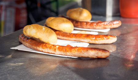 Grilled sausages with buns on a table in a restaurantの写真素材