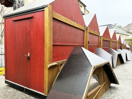 Red market stalls with collapsible roofs in outdoor setting.の写真素材