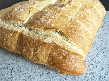 Freshly baked traditional square bread loaf on granite surface.