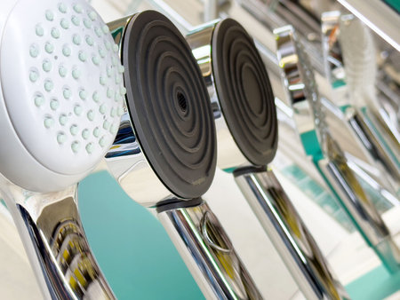 Variety of modern showerheads display in a bathroom showroom setting.