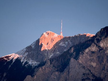 Sunlit mountain peak with antenna at sunrise.の写真素材