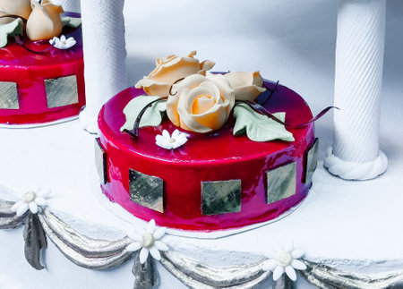 Luxurious red cake with elegant sugar roses and gold accents.の写真素材