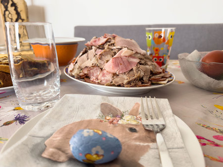 Easter brunch table setting with ham and colorful decor.