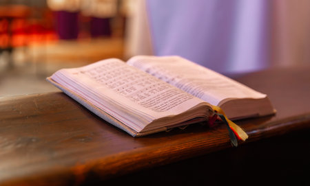 Open hymn book on wooden church pew with selective focus on musical notes.の写真素材