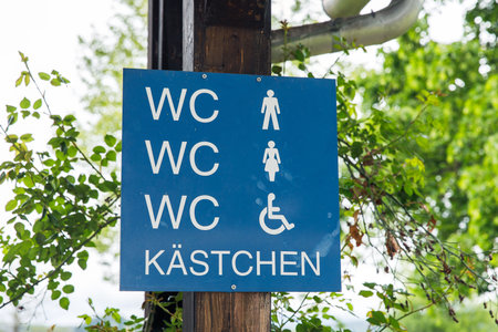 Blue outdoor restroom sign with male, female, and accessible symbols.の写真素材