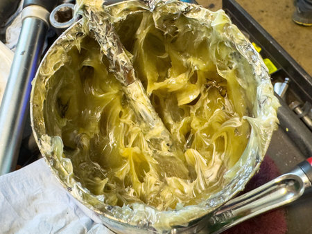 Close-up of grease in metal container with mixing tool.