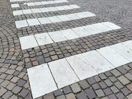 Cobblestone pedestrian crossing on urban street with interlocking pavers.の写真素材