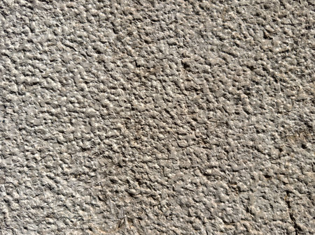 Close-up of rough textured concrete wall surface with natural patterns.の写真素材