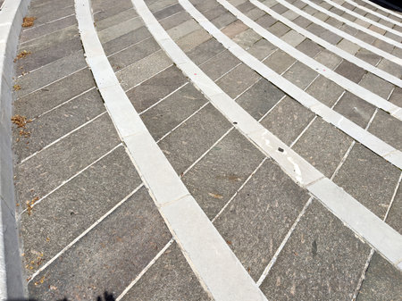 Curved stone staircase with white stripes in outdoor setting.の写真素材
