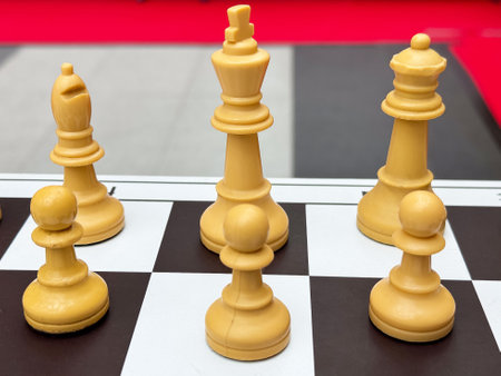 Close-up of chess pieces on a black and white board: king, queen, bishop, pawns.の写真素材