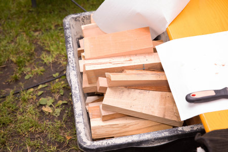 Wooden planks and tools in outdoor workshop setting with grass background.の写真素材