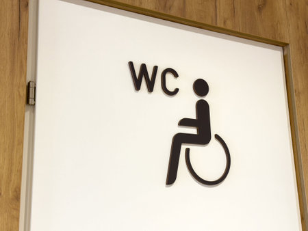 Wheelchair accessible wc sign on wooden door for inclusive restroom entrance.の写真素材