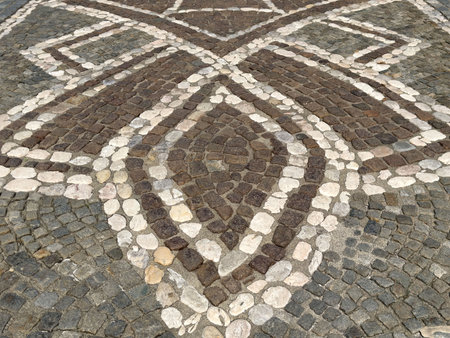 Intricate geometric stone mosaic pattern on pavement surface.の写真素材