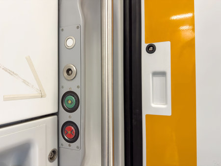 Close-up of train door panel with buttons and latch.