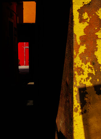 Vivid urban alleyway with bold color contrasts and strong light reflection.の写真素材