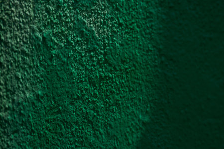 Close-up of textured green wall surface with shadows.の写真素材