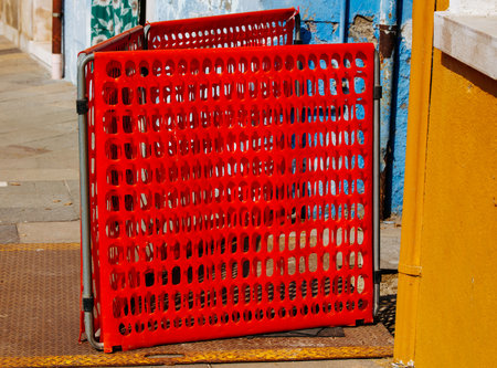 Red temporary fence in colorful urban alleyway.の写真素材