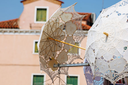 Elegant lace parasols against mediterranean architecture on a sunny day.の写真素材