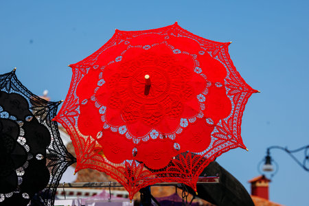 Colorful lace parasols against blue sky in sunny marketplace.の写真素材