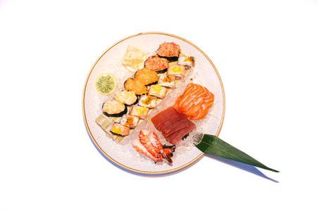 Assorted sushi platter with sashimi and nigiri on ice with leaf garnish and lime slice.の写真素材