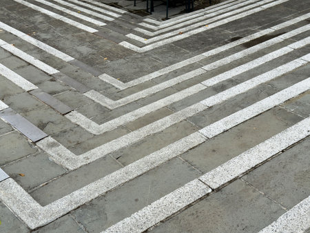 Abstract geometric pattern on gray stone pavement with white lines.の写真素材